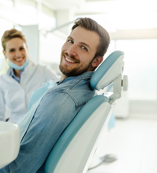 Happy dental patient smiling over his shoulder