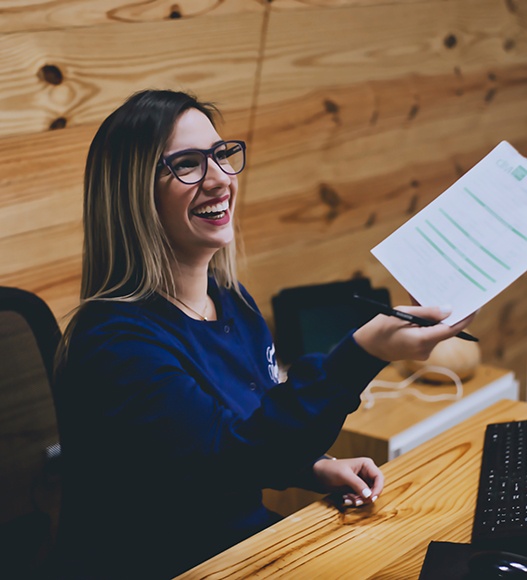 Receptionist in dental office giving paperwork to a patient